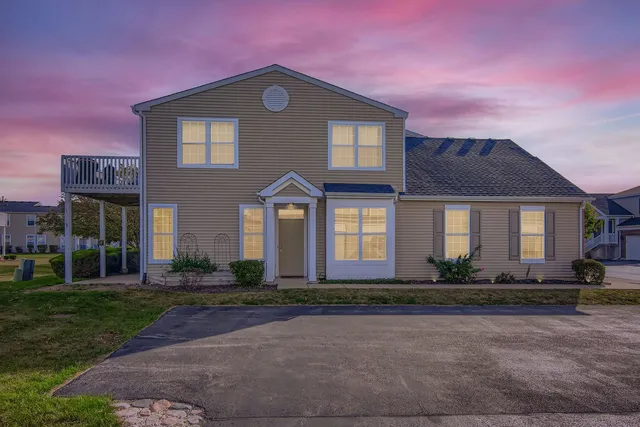 a front view of a house with lots of trees and plants
