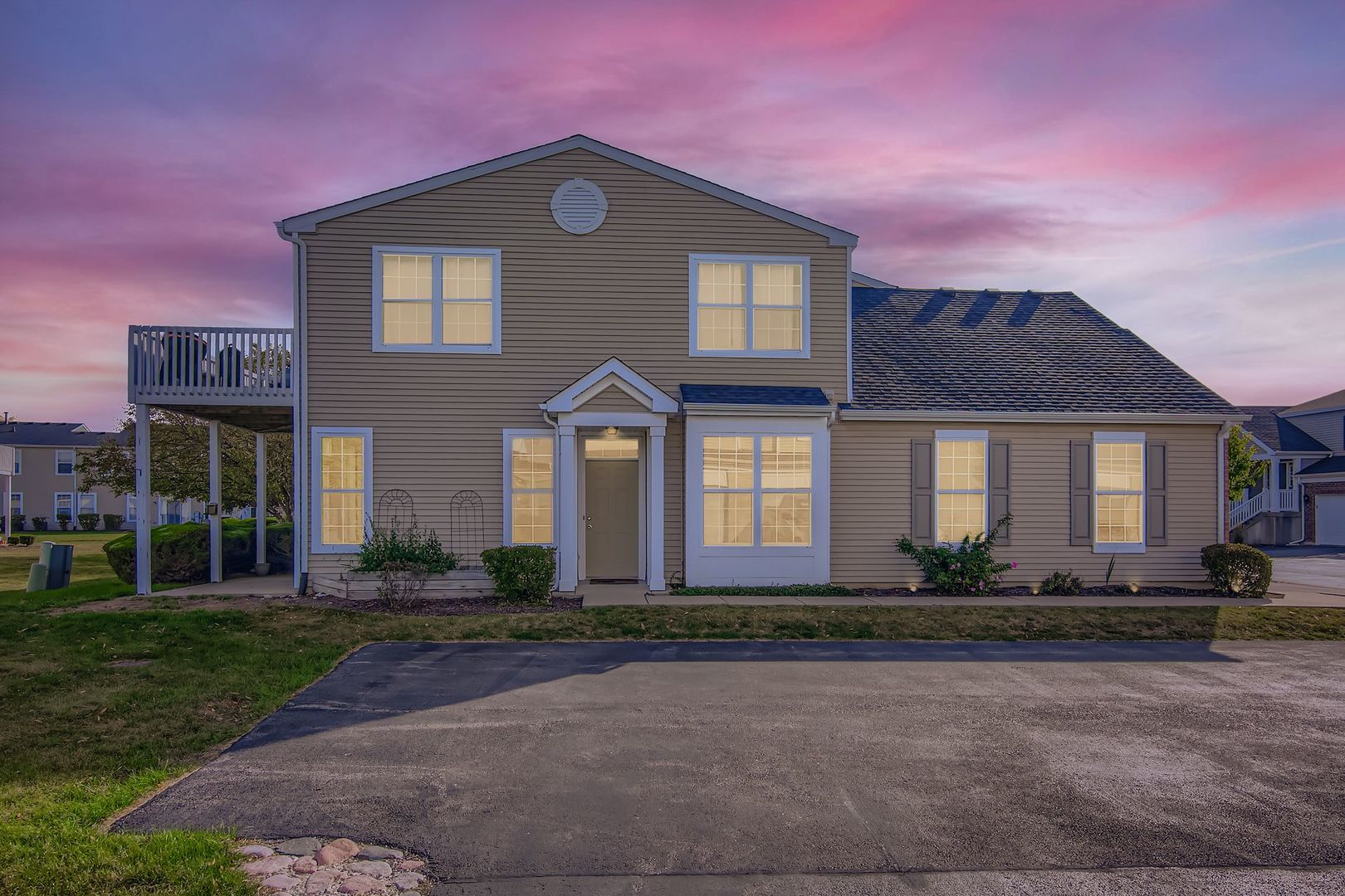 a front view of a house with lots of trees and plants