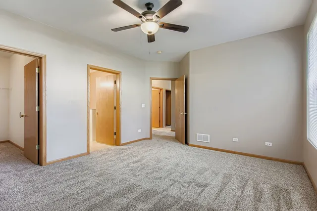 a view of an empty room and chandelier fan