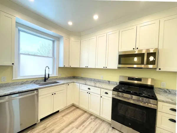 a kitchen with stainless steel appliances granite countertop a stove a sink and a microwave