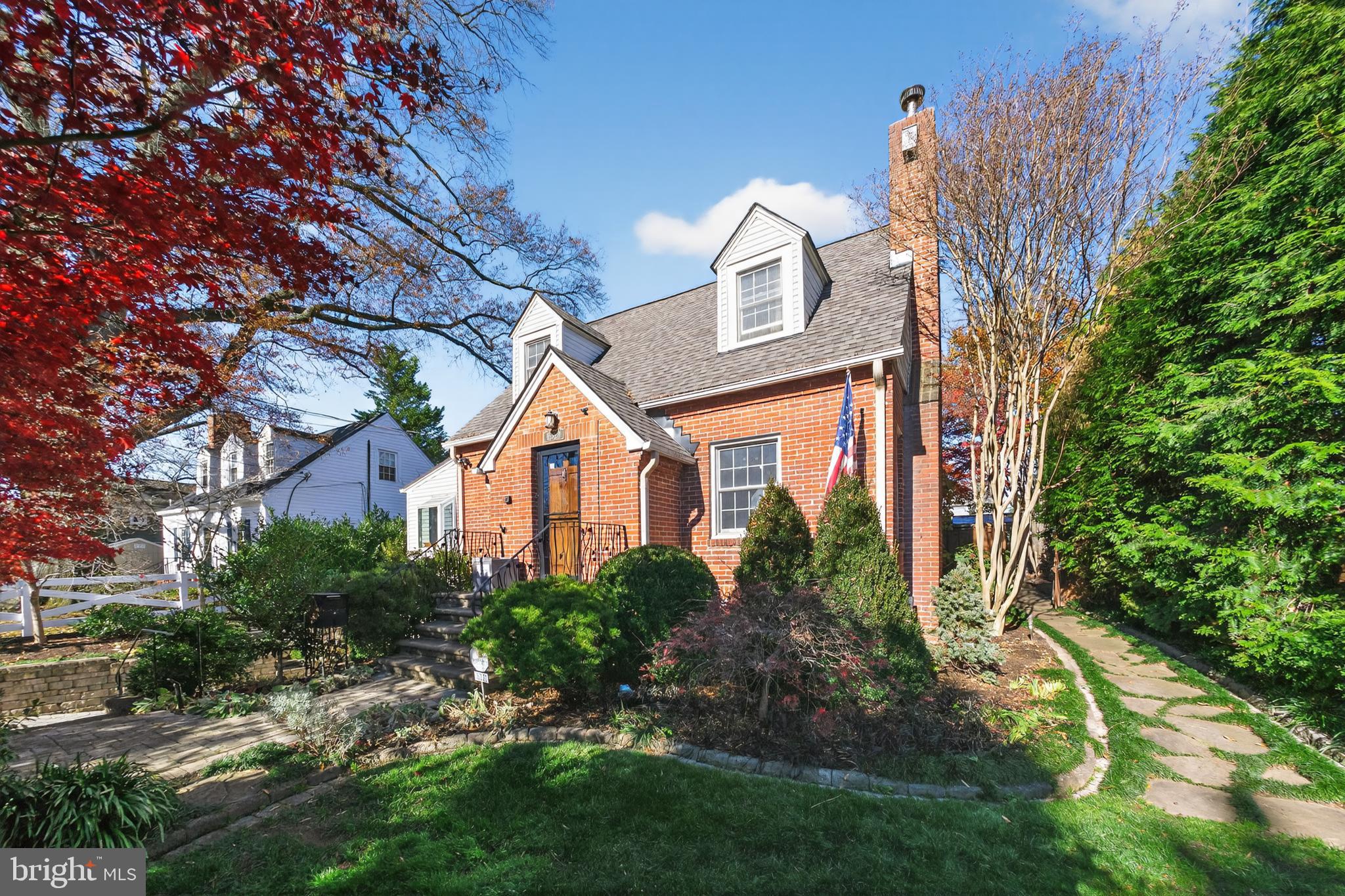 Charming brick home with vibrant landscaping.