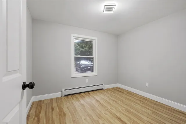 a view of a room with wooden floor and window