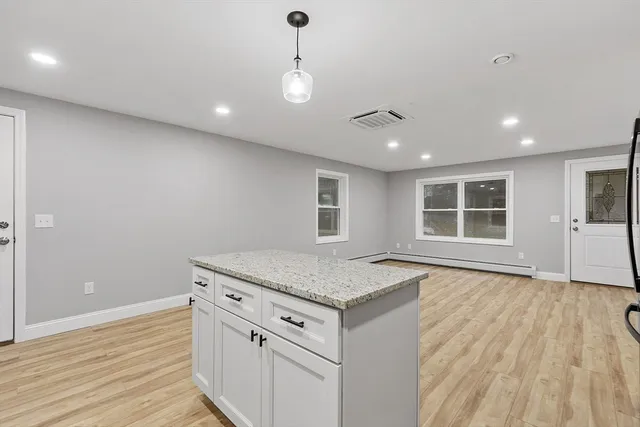 a view of kitchen with granite countertop cabinets and wooden floor