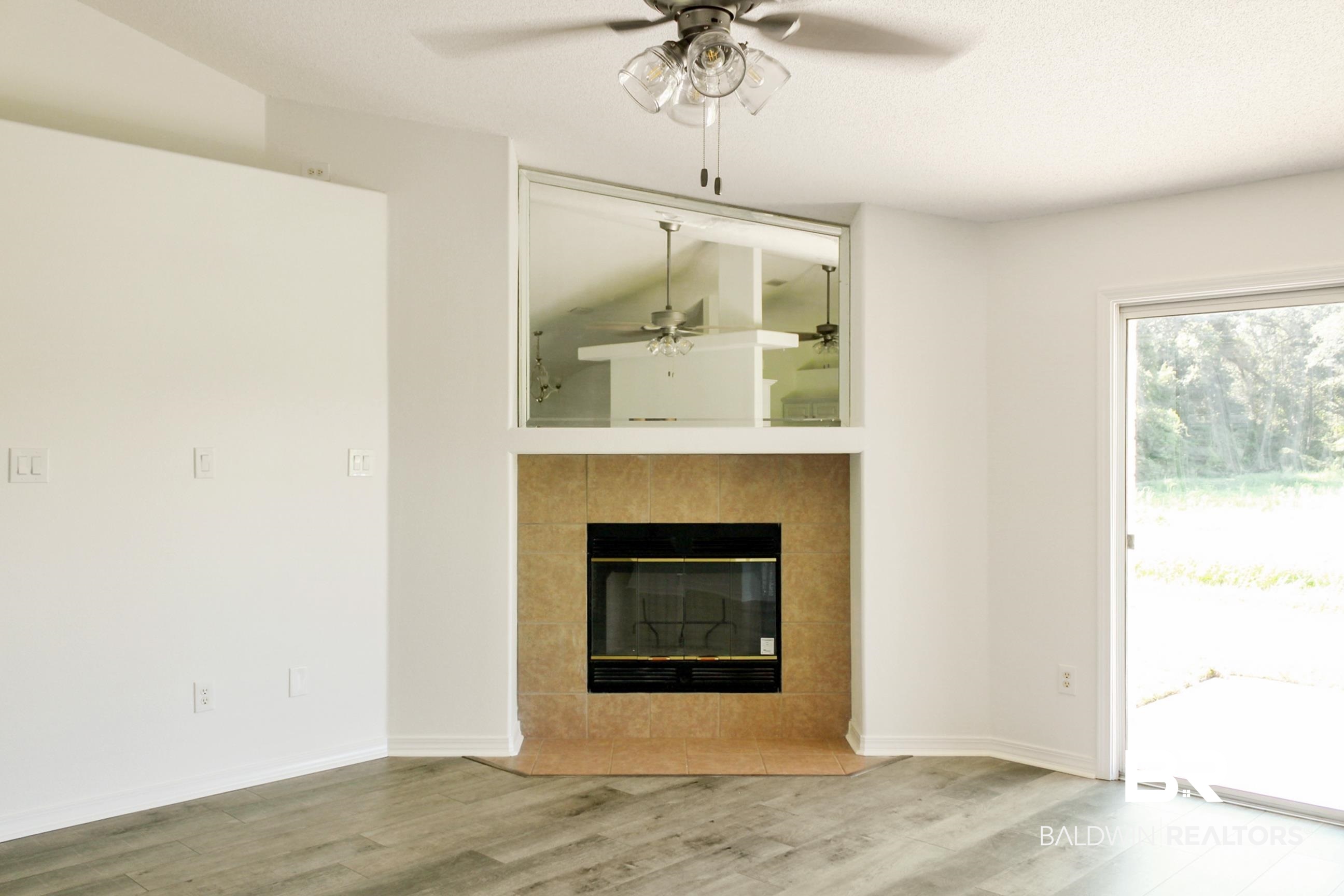 14750 Pawnee Court Foley, AL 36535 - Photo 13 of 34 Unfurnished living room with a ceiling fan, wood finished floors, and a fireplace