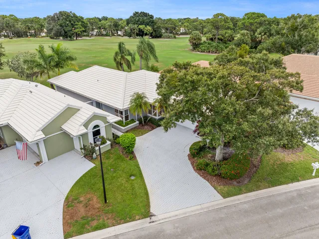 an aerial view of residential houses with outdoor space and trees