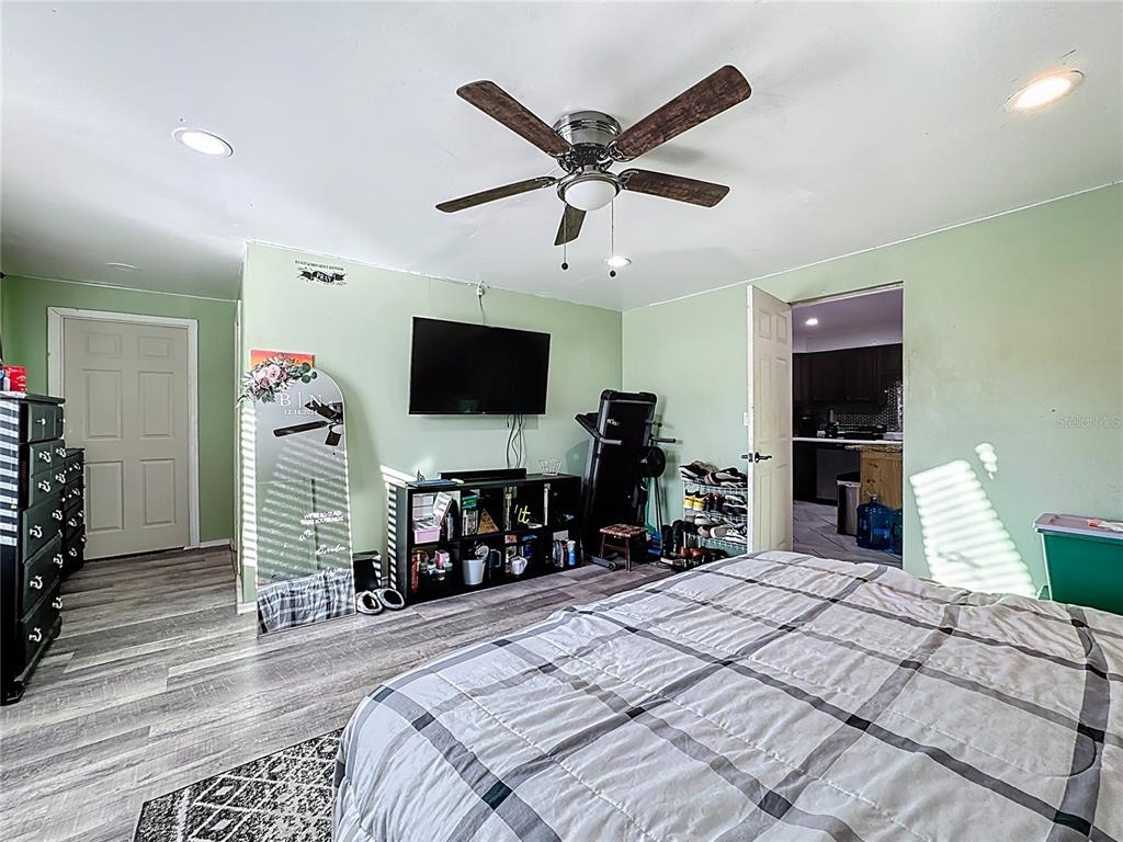 7717 Clarcona Ocoee Road Orlando, FL 32818 - Photo 18 of 63 a bedroom with a bed and a flat tv screen on dresser