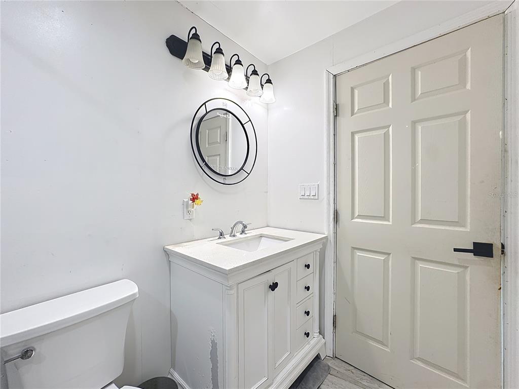 7717 Clarcona Ocoee Road Orlando, FL 32818 - Photo 19 of 63 a bathroom with a sink a toilet and a mirror