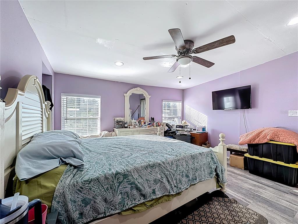 7717 Clarcona Ocoee Road Orlando, FL 32818 - Photo 21 of 63 a bedroom with a bed a dresser and flat screen tv