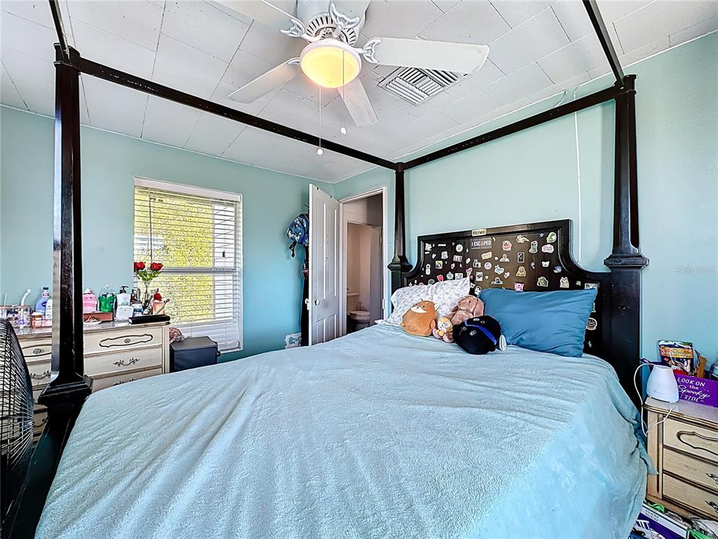 7717 Clarcona Ocoee Road Orlando, FL 32818 - Photo 30 of 63 a bed room with a bed and a chandelier