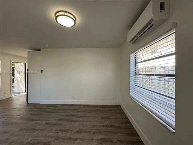 a view of a room with wooden floor and window