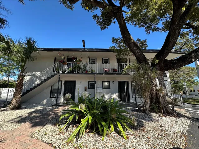 a view of a house with a tree in front of it