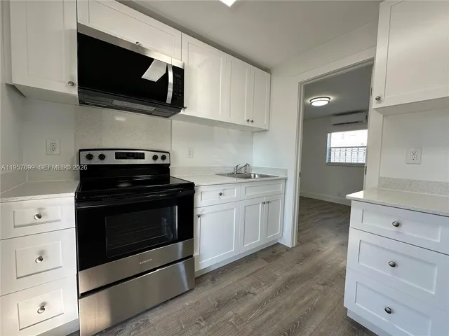 a kitchen with stainless steel appliances a stove microwave and cabinets