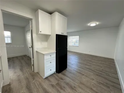 a kitchen with wooden floors and white cabinets