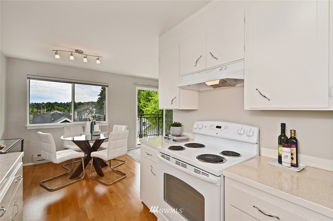 911 North 73rd Street, Unit 407 Seattle, WA 98103 - Photo 11 of 27 a kitchen that has a stove and a table chair in it