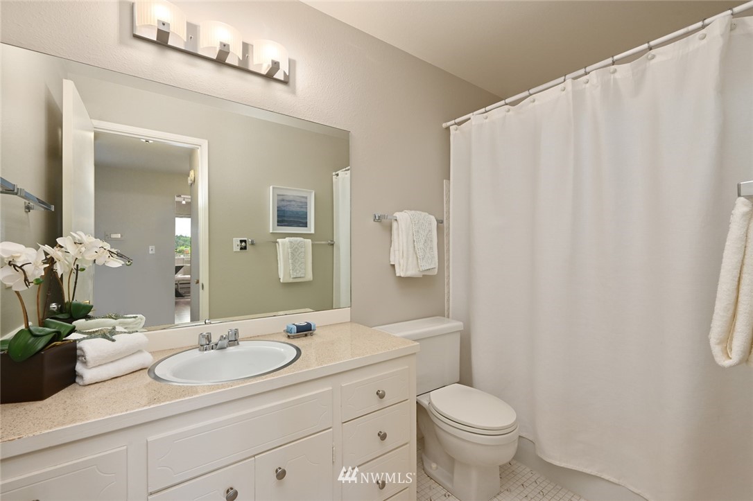 911 North 73rd Street, Unit 407 Seattle, WA 98103 - Photo 23 of 27 a bathroom with a sink a toilet and a mirror