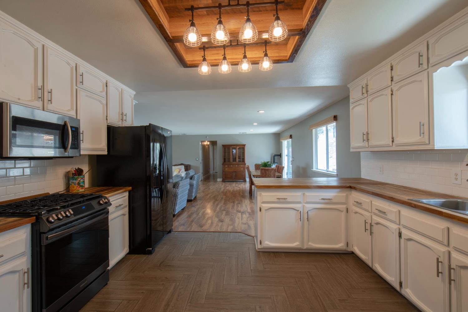 29395 Revis Road Coarsegold, CA 93614 - Photo 19 of 32 a large white kitchen with stainless steel appliances granite countertop a stove and a sink