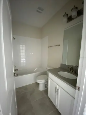 a bathroom with a granite countertop sink a toilet a mirror and shower