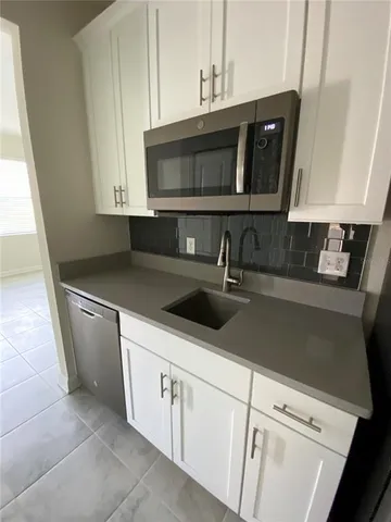 a kitchen with a sink and a stove top oven