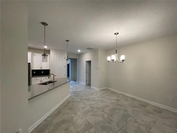 an empty room with kitchen and fireplace