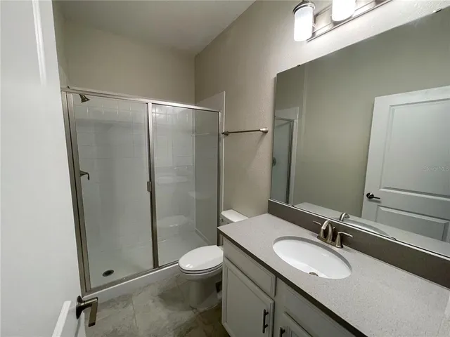 a bathroom with a double vanity sink mirror and toilet