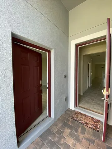 a view of a hallway with wooden floor and a bathroom