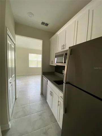 a kitchen with granite countertop a refrigerator and a sink