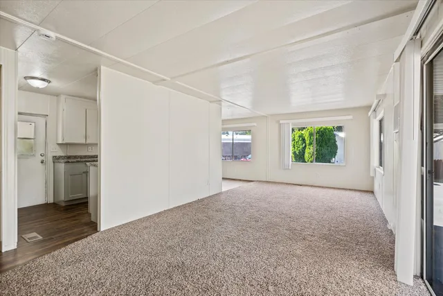 a view of an empty room with a kitchen