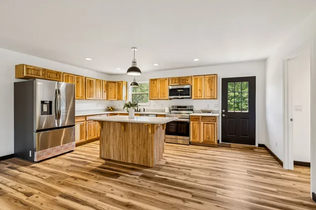 a kitchen with stainless steel appliances a refrigerator stove top oven and sink