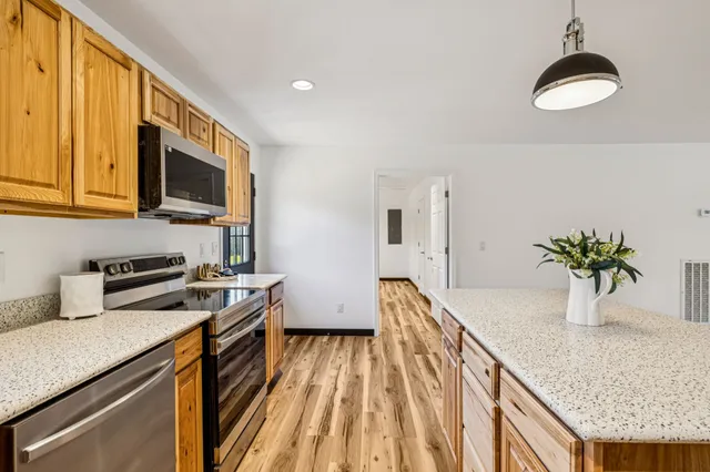 a kitchen with a sink a counter top space stainless steel appliances and cabinets