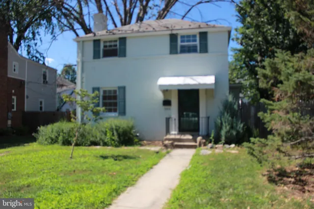 a view of a house with brick walls and a yard with plants