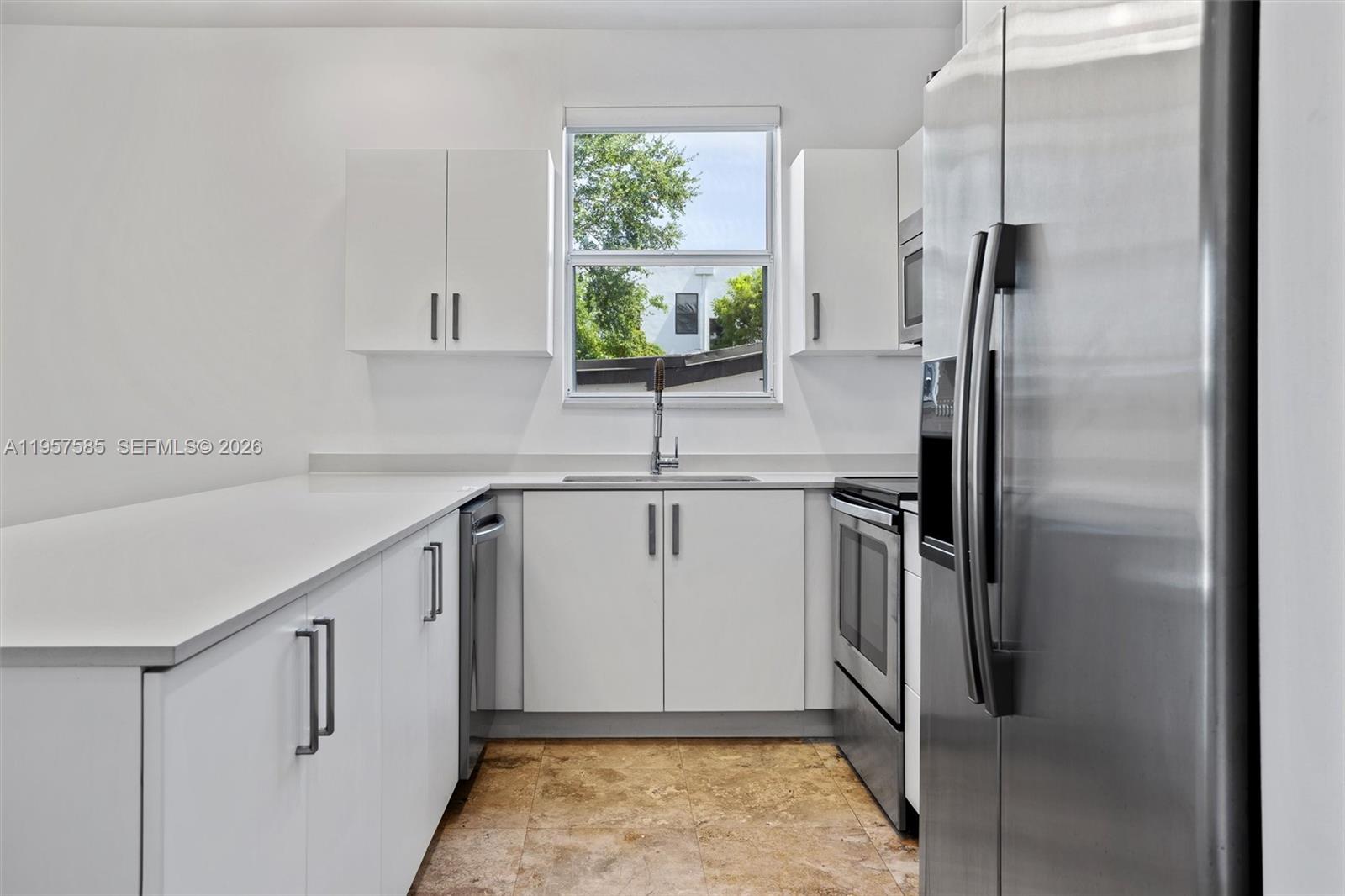 2784 Southwest 34th Avenue Miami, FL 33133 - Photo 13 of 45 a kitchen with stainless steel appliances granite countertop a refrigerator and a sink