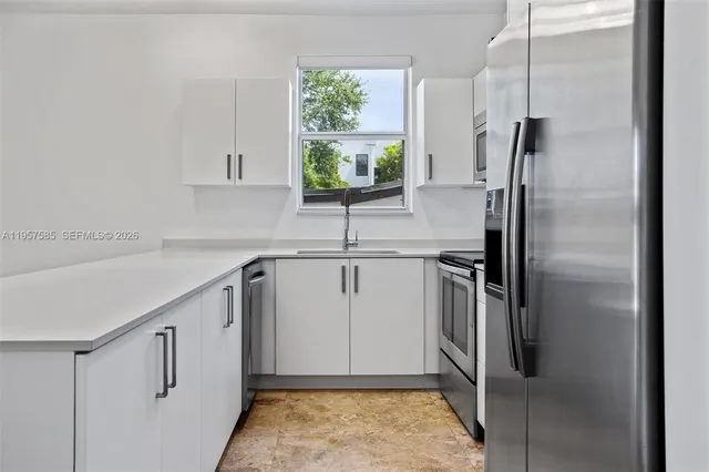 a kitchen with stainless steel appliances granite countertop a refrigerator and a sink