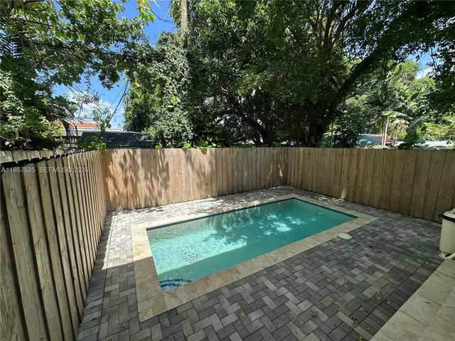 a view of a yard with wooden fence