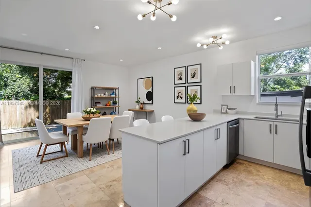 a kitchen with a sink dining table and chairs
