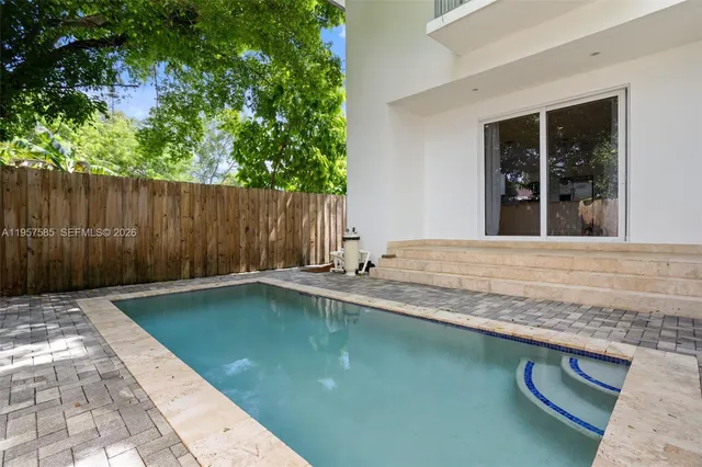 a swimming pool with a outdoor seating yard and wooden fence