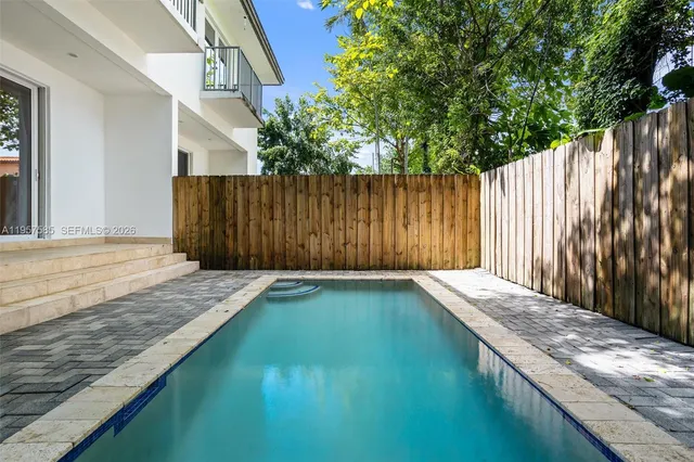 a view of backyard with wooden fence