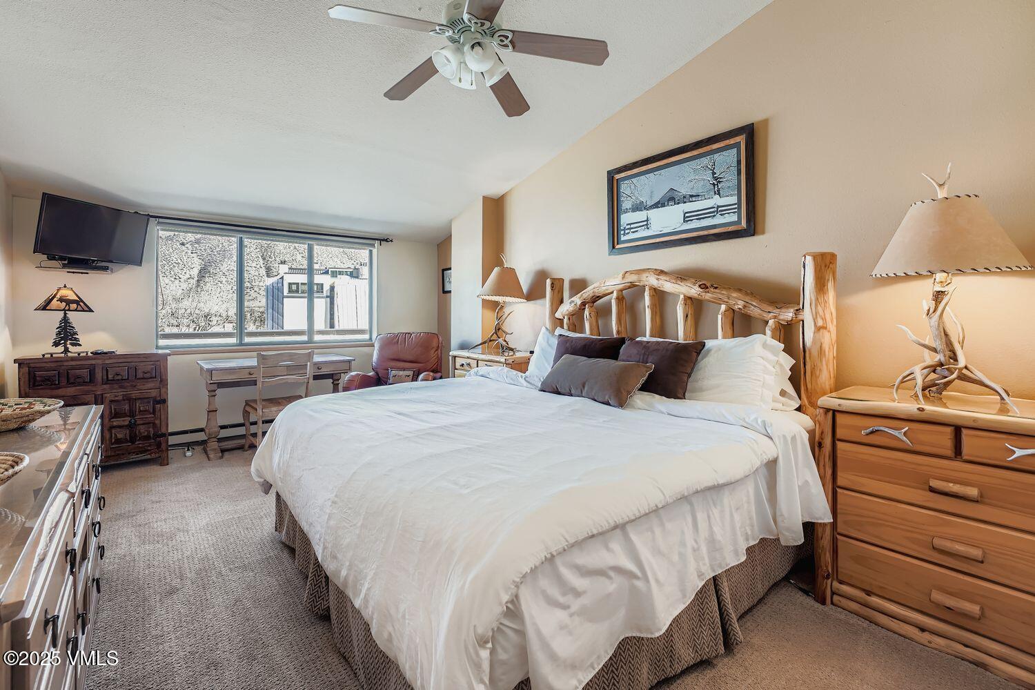 137 Benchmark Road, Unit 520 Avon, CO 81620 - Photo 13 of 26 a bedroom with a bed and wooden floor