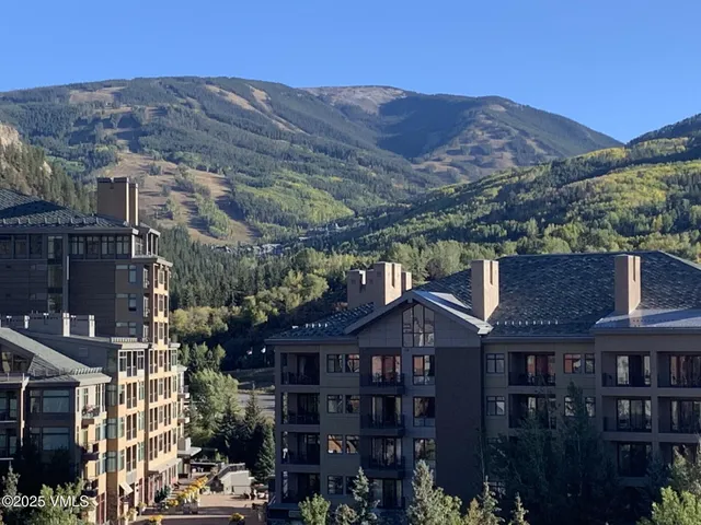 a front view of a houses with a yard and mountain view in back