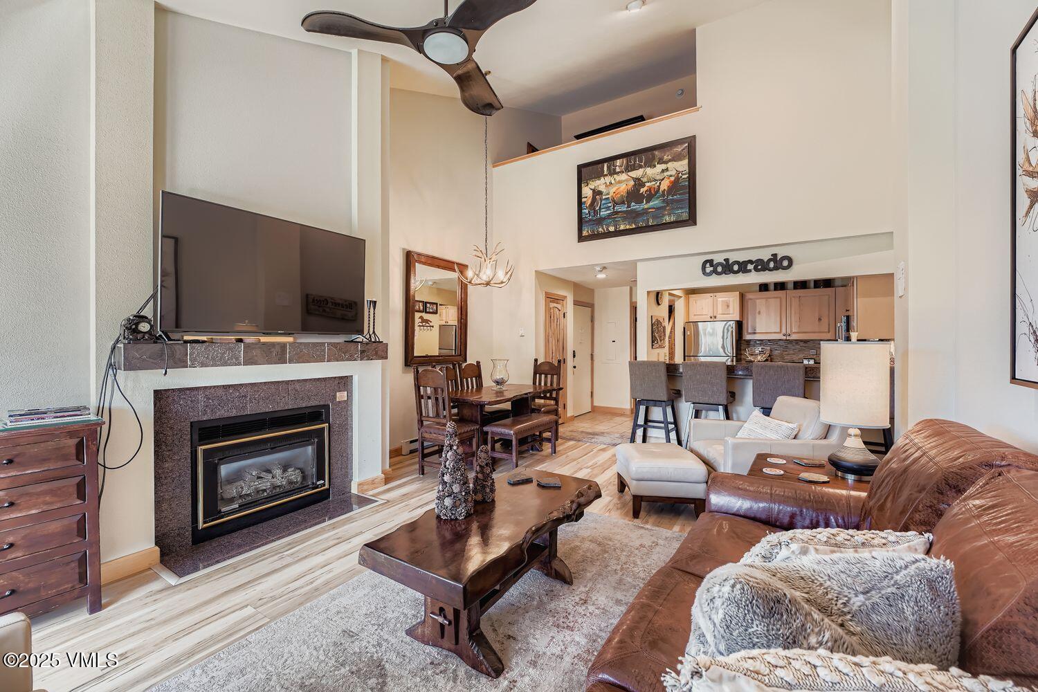 137 Benchmark Road, Unit 520 Avon, CO 81620 - Photo 2 of 26 a living room with furniture a fireplace and a flat screen tv