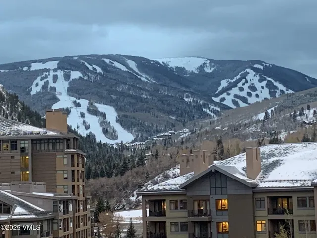 a front view of a building with a mountain