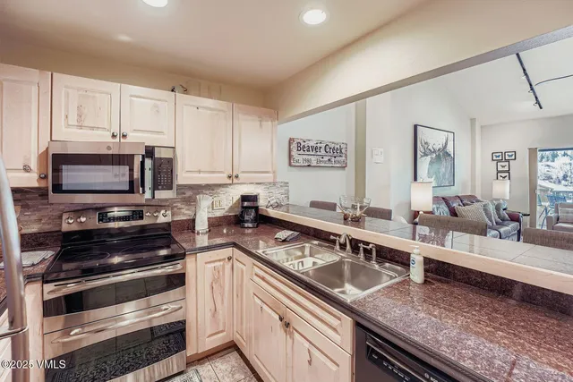 a kitchen with stainless steel appliances granite countertop a stove a sink and a microwave