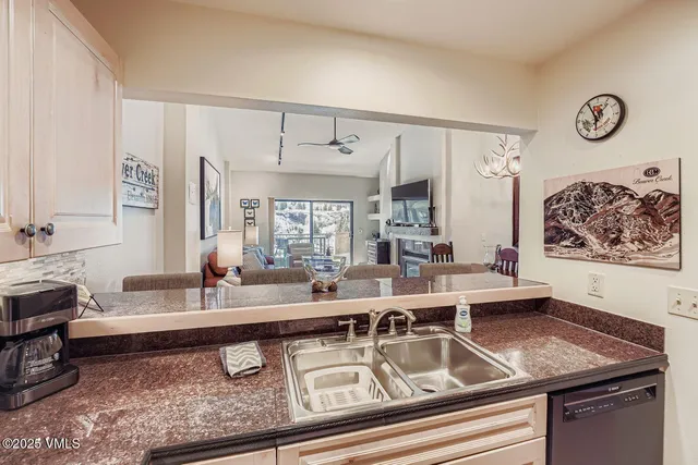 a kitchen with a sink and a stove with wooden floor