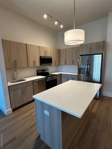 a kitchen with kitchen island a sink a stove a microwave a center island and cabinets