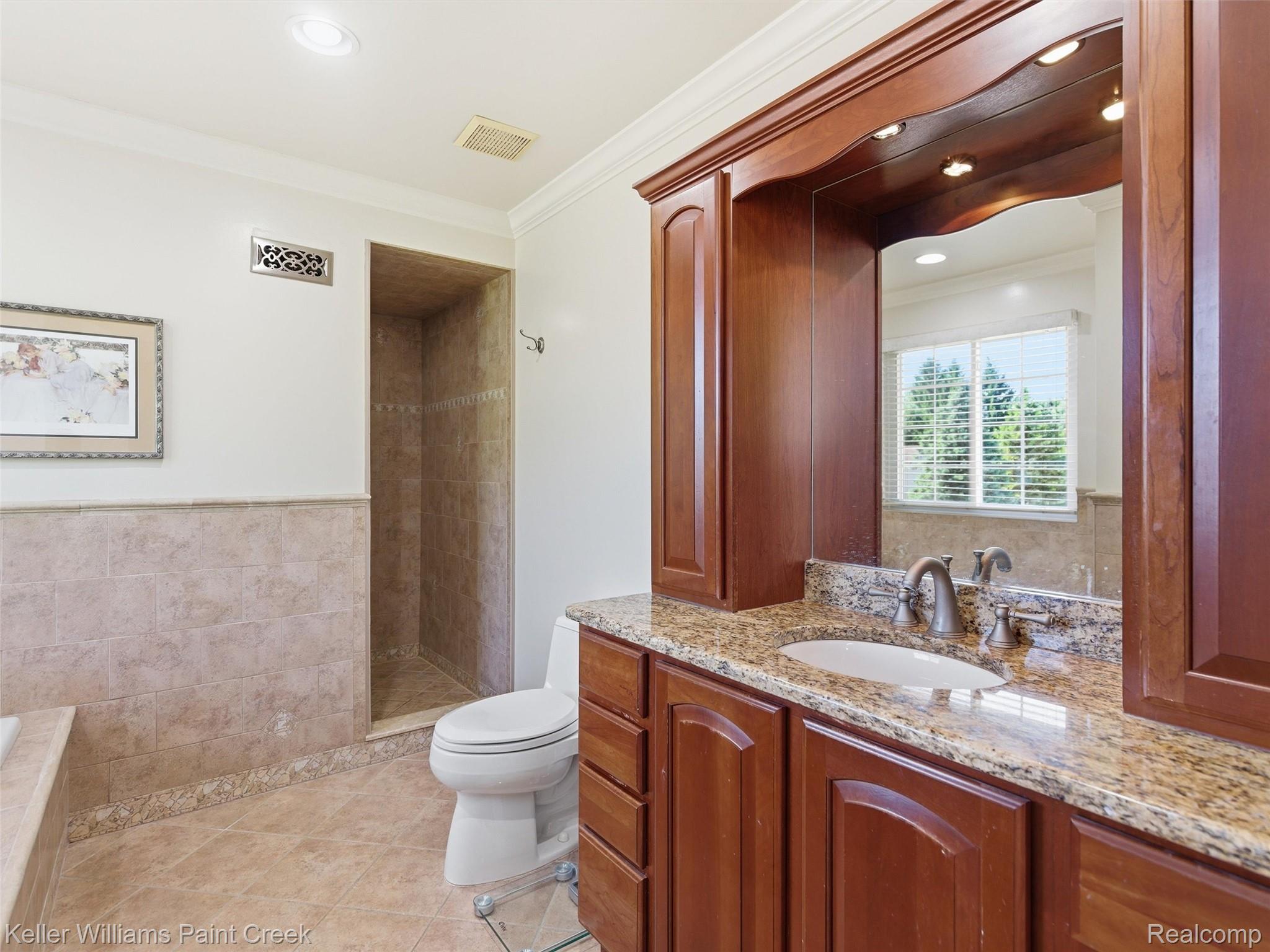 2842 Manorwood Road Troy, MI 48085 - Photo 48 of 72 Bathroom featuring an integrated walk-in shower with tiled walls, a wood-finish vanity with a stone countertop, an undermount sink, and brushed nickel fixtures