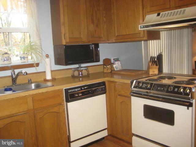 705 Sycamore Leaf Road Severn, MD 21144 - Photo 8 of 18 a kitchen with a stove a sink and a microwave