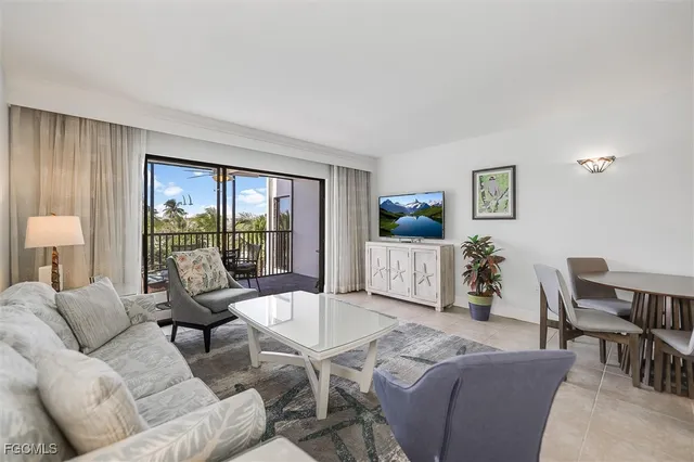 a living room with furniture and view of kitchen