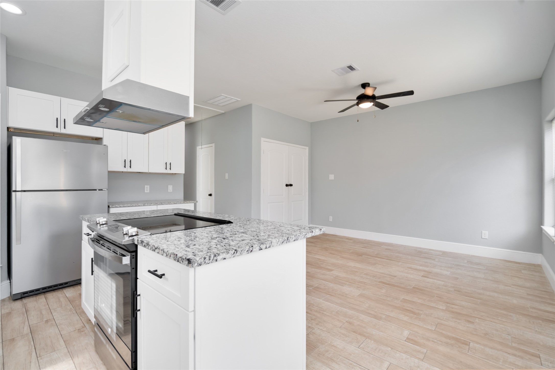 5754 Reed Road, Unit B Houston, TX 77033 - Photo 11 of 29 a kitchen with a stove a refrigerator and ceiling fan
