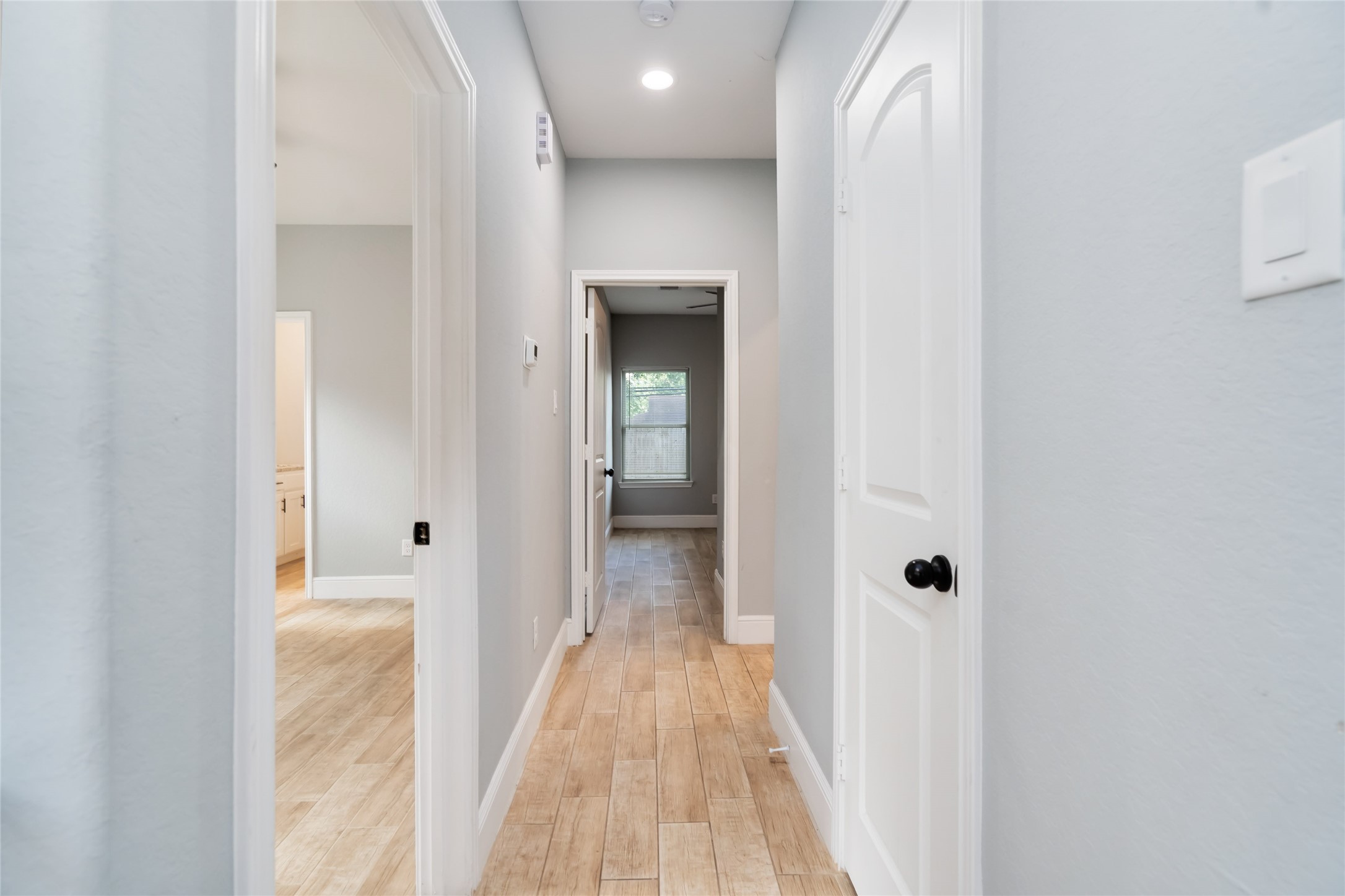5754 Reed Road, Unit B Houston, TX 77033 - Photo 13 of 29 a view of a hallway with wooden floor and a bathroom