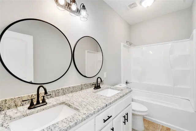 a bathroom with a granite countertop sink mirror and vanity