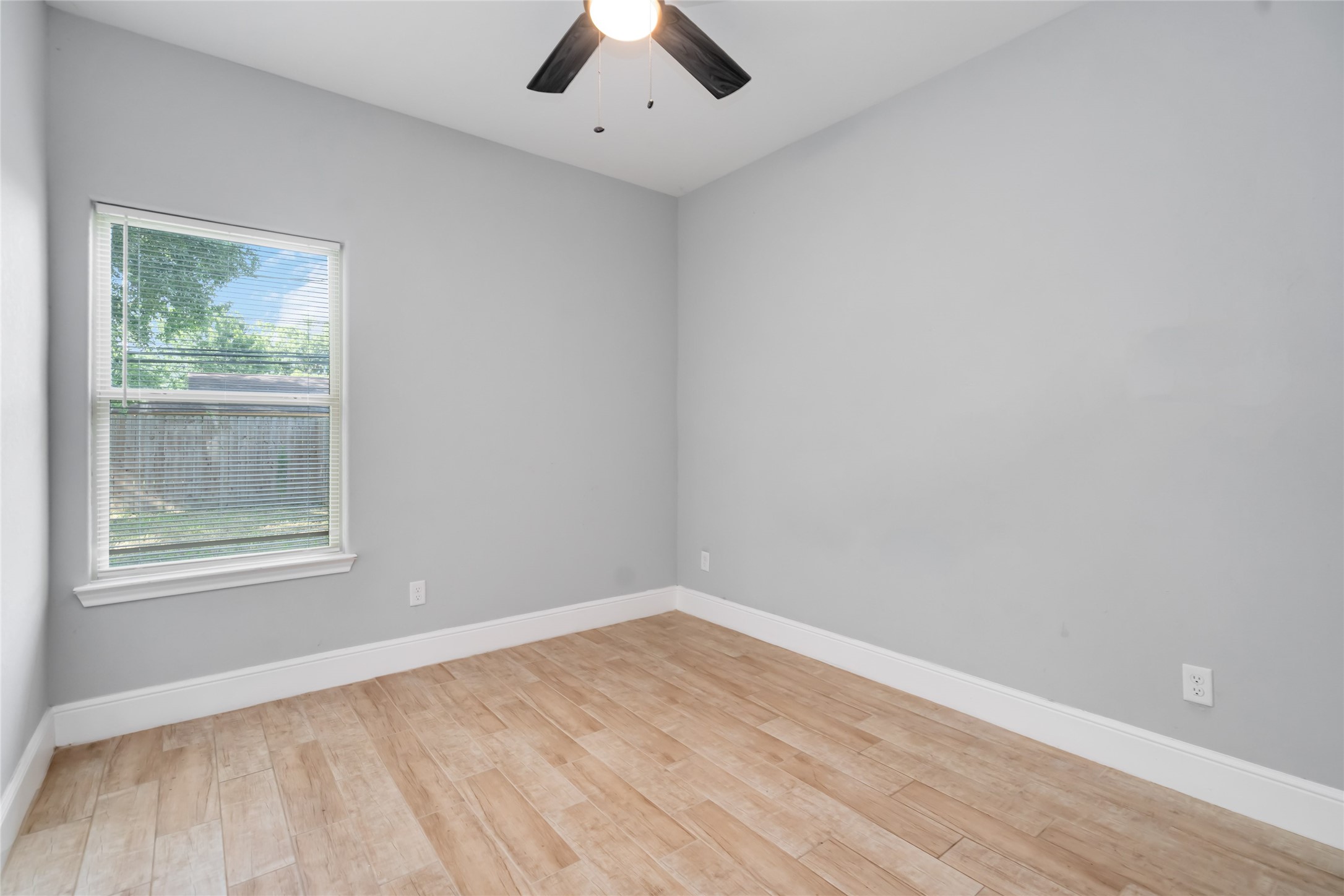 5754 Reed Road, Unit B Houston, TX 77033 - Photo 22 of 29 an empty room with a window and a ceiling fan